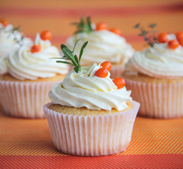 Tasty vanilla cupcakes with sea buckthorn berries