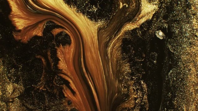 Glitter ink mix. Mountain landslide. Golden black fluid flow motion background.