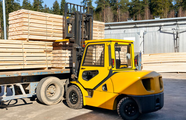 The machine loads the boards, lumber from the finished goods warehouse onto the truck