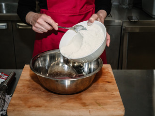 The process of making pancakes. Cook in the kitchen makes the dough.