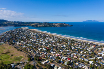 Aerial View from the Beach, Green Trees, City Streets and Waves of Omaha in New Zealand - Auckland Area	 - obrazy, fototapety, plakaty