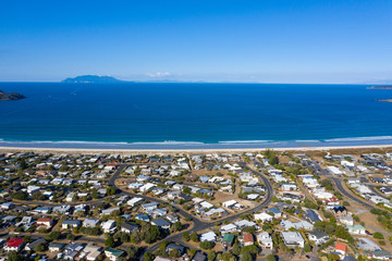Aerial View from the Beach, Green Trees, City Streets and Waves of Omaha in New Zealand - Auckland Area	 - obrazy, fototapety, plakaty