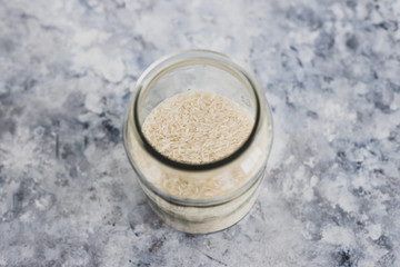 non-perishable food ingredients for vegan pantry, glass jars with oats flour and rice