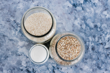 non-perishable food ingredients for vegan pantry, glass jars with oats flour and rice