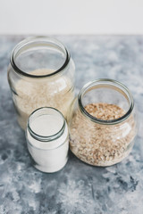 non-perishable food ingredients for vegan pantry, glass jars with oats flour and rice