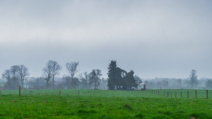 Heavy rain falling over the Normandy countryside in winter