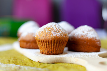 homemade cake muffin dusted with powder with purple and green backgrounds