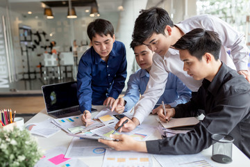 Young professional asian business men team. Group of creative young business men brainstorming, analyzing and planning to work together at the meeting.
