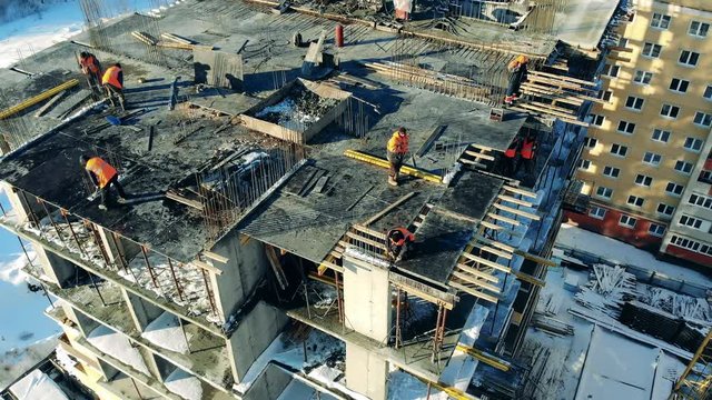 A group of workers on top of a building under construction