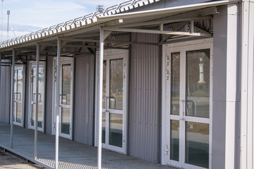 Entrance with identical doors. Visor made of metal. The concept of the passage and separation of a large number of people, isolated boxes.
