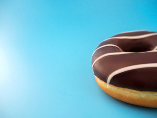chocolate donut on a blue background on the side of the frame