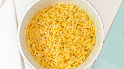 Creamy delicious macaroni and cheese close up in a bowl, view from above