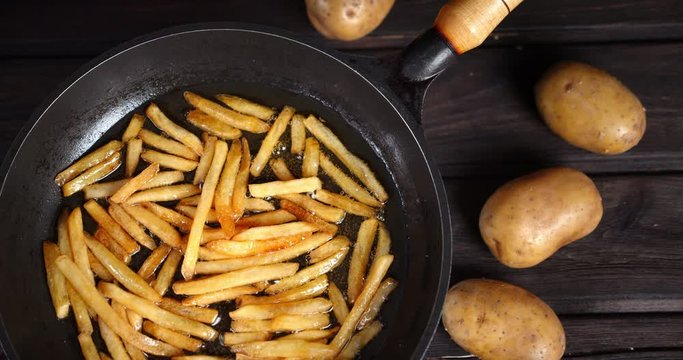 French fries fried in oil in a frying pan.
