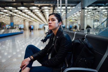 Woman traveling with carry on backpack hand luggage to destination with low cost avio company with small budget.Tired traveler having problems at the airport, lost luggage, delayed flight,headache