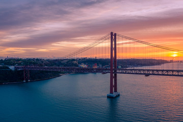 Lisbon, Portugal. Aerial view of the 25 de Abril Bridge (Ponte 25 de Abril, 25th of April Bridge) at sunset. It is often compared to the Golden Gate Bridge in San Francisco, US.