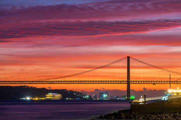 Lisbon, Portugal. Aerial view of the 25 de Abril Bridge (Ponte 25 de Abril, 25th of April Bridge) at sunset. It is often compared to the Golden Gate Bridge in San Francisco, US.