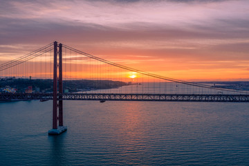 Lisbon, Portugal. Aerial view of the 25 de Abril Bridge (Ponte 25 de Abril, 25th of April Bridge) at sunset. It is often compared to the Golden Gate Bridge in San Francisco, US.