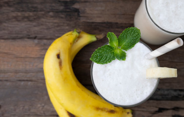 Banana fresh cocktail vanilla smoothies  fruit juice beverage healthy the taste yummy in glass drink episode good morning on wooden background from the top view.