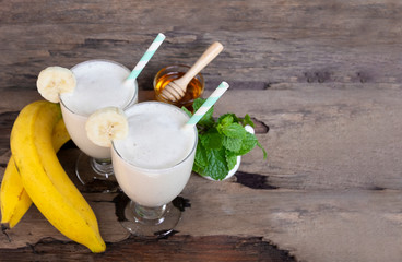 Banana fresh cocktail vanilla smoothies  fruit juice beverage healthy the taste yummy in glass drink episode good morning on wooden background from the top view.