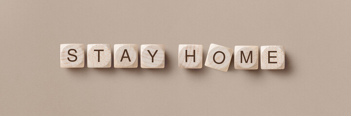 corona virus warning themed banner or header with wooden dices reading stay at home as a quarantine...