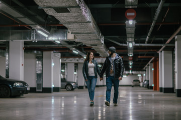 Fototapeta premium szczęśliwa para spaceru w podziemnym parkingu centrum handlowego