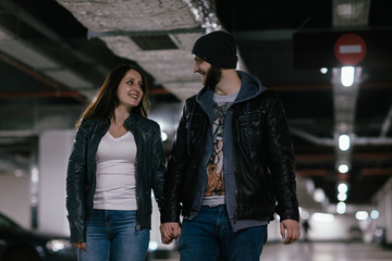 couple in love walks in the underground parking of a shopping center