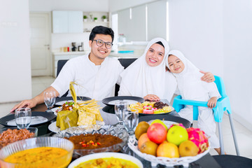 Daughter and muslim parents smiling at camera