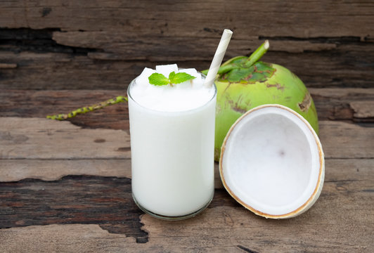 Coconut smoothie drink white fresh cocktail shake milkshake vanilla juice fruit beverage food healthy the taste yummy In glass on wooden background.