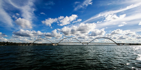 Ponte JK sobre o Lago Paranoá em Brasília em um lindo dia de sol com céu azul e nuvens