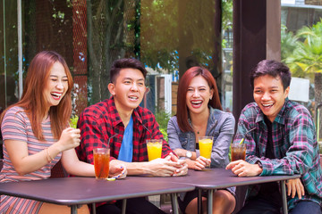 Joyful young people laughing together in cafe