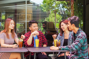 People sit in cafe while chatting to each other
