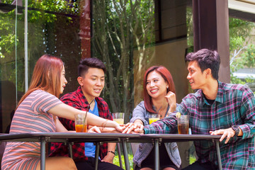 Young people joining hands together in cafe