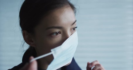 Woman putting on surgical face mask for protection against coronavirus SARS-CoV-2. SLOW MOTION on RED Cinema camera. - Powered by Adobe
