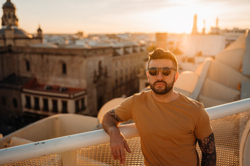 Handsome spanish man enjoying sunset time from a cityscape viewpoint.Having tapas and drinks with a view.Tourist in Seville,Andalucia,Spain.Opportunities,seasonal work and experience in Andalucia.