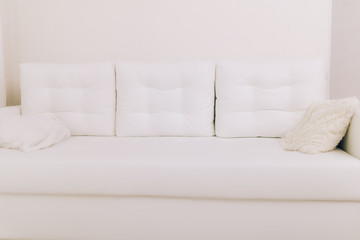 Beautiful white sofa with pillows in a white room, interior, design