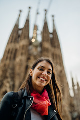 Smiling spanish woman visiting famous landmarks and attractions,gothic church Sagrada Familia,in...