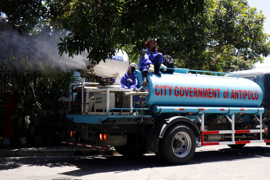 Local government workers spray disinfectant to a community during the Covid 19 virus outbreak
