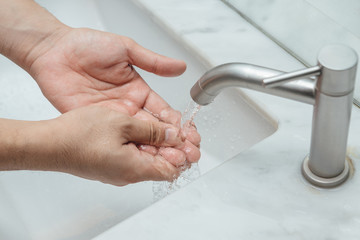 Rubbing the fingers under the running water.