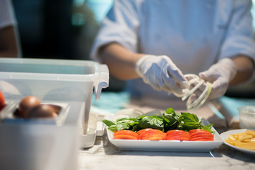 Female chef  is preparing vegetable in kitchen