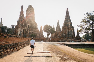 Traveler tourist man walking at Chaiwatthanaram temple of Ayutthaya in the Thailand. ayutthaya historical park, Ayutthaya, Thailand. - obrazy, fototapety, plakaty