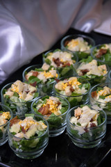 Cesar salad in row of glasses - canepe cocktail food