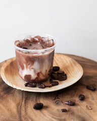 Ice chocolate drink with foam and cacao beans  isolated on white background.