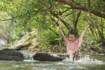 happy little asian girl and child having fun to playing in the river in summer time with smile and laughing healthy, smiling face adorable. Summer camp for kids. vacation lifestyle concept.