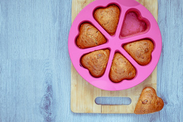Homemade cupcakes in a baking mould on a wooden board