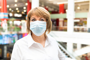 A woman in a virus mask walks around a public place in the city.