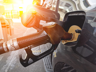 Closeup of pumping gasoline fuel, car being filled gasoline at gas station