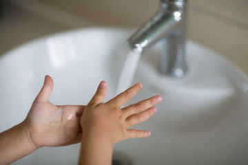 Hygiene concept. Kid Washing hands with soap under the faucet with water. Hygiene to stop spreading coronavirus.