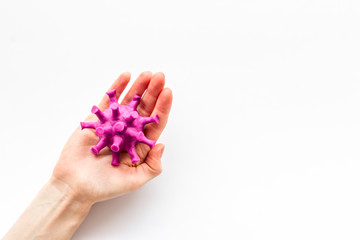 Corona virus Covid-19 - diagnostics concept with strain virus model and hands - on white background top-down copy space