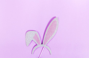 Top view of paper bunny ears on purple background. Easter celebration