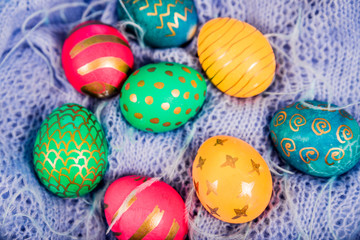 Fototapeta na wymiar Colored easter eggs on a blue knitted background